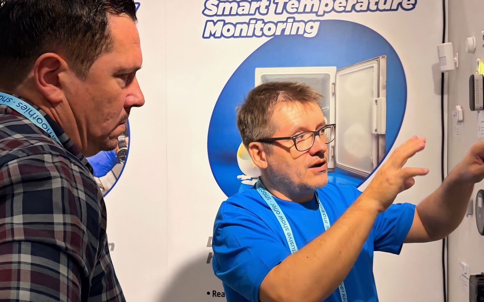 Albert showing a visitor the live temperature-monitoring dashboard at the °Celsi stand